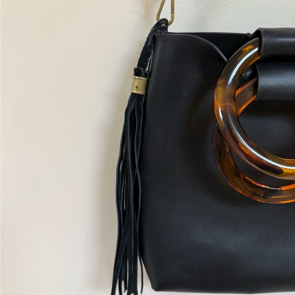 Elegant Black Bag with Tortoiseshell Handles and Tassel
